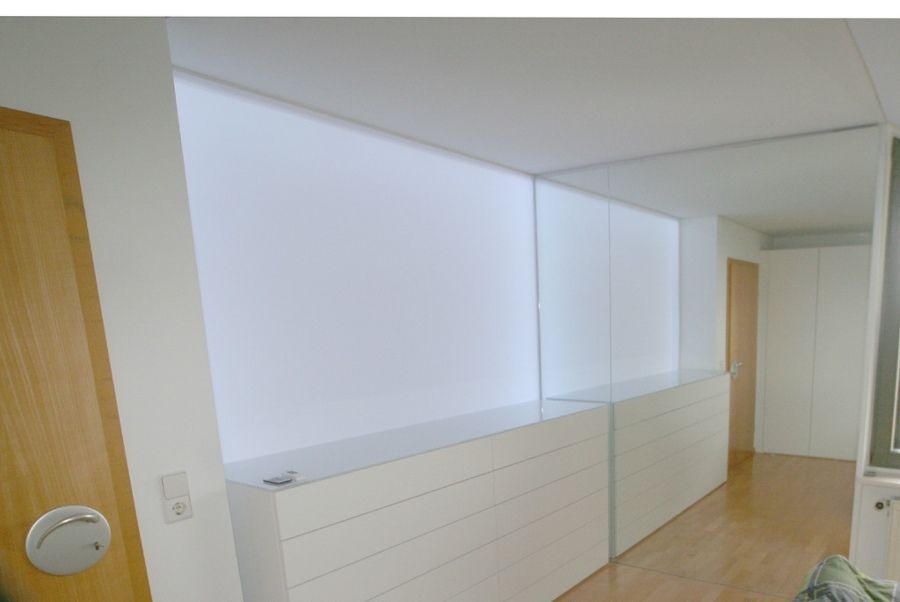 Ein Zimmer mit einer Kommode und einem Spiegel an der Wand