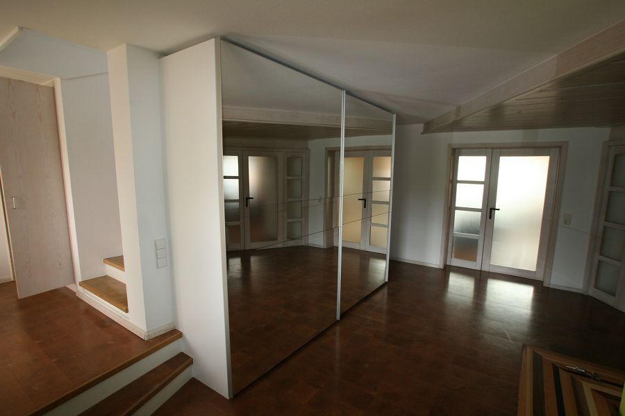 Ein leerer Raum mit einem großen Spiegel an der Wand