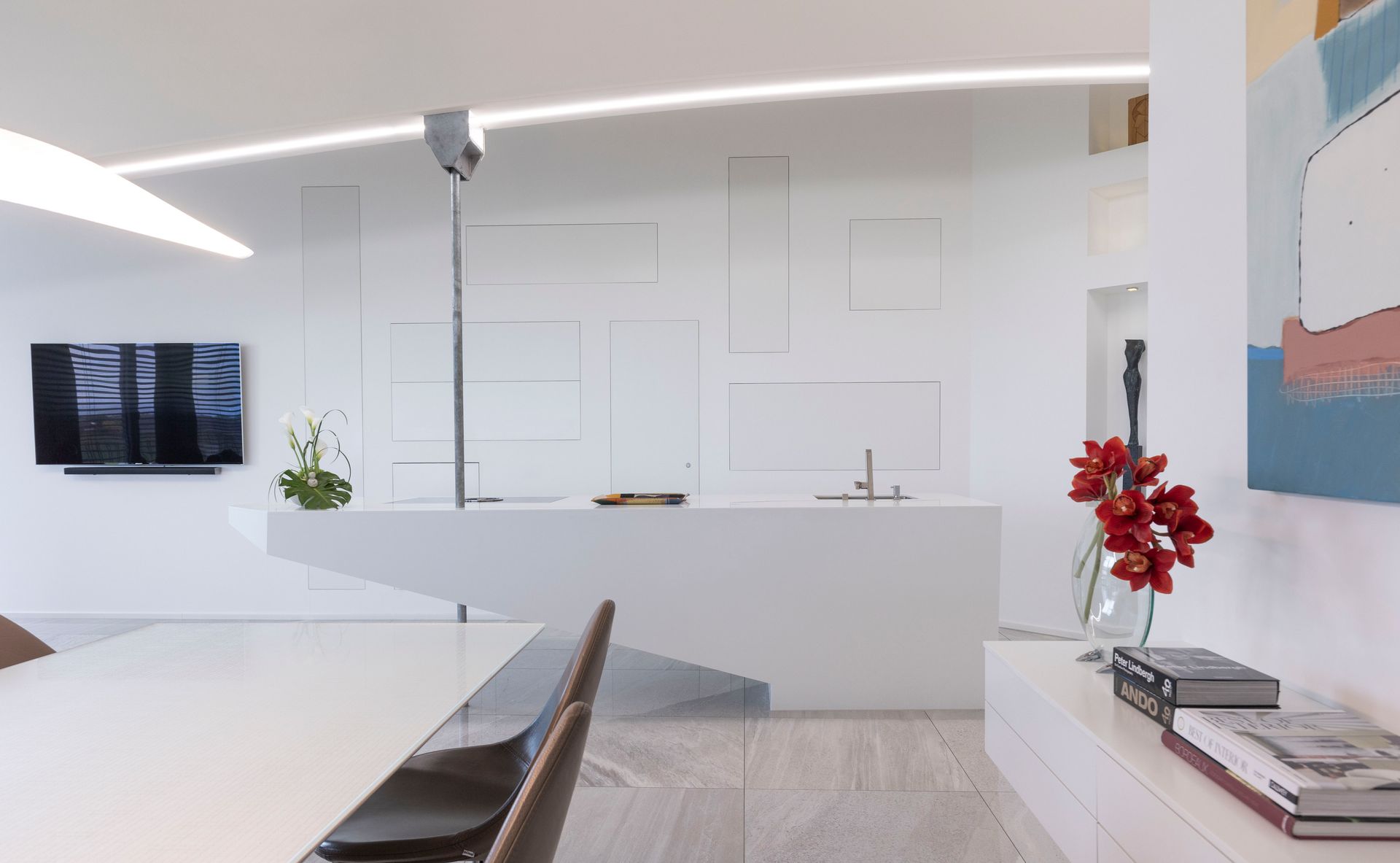 Ein Wohnzimmer mit Tisch und Stühlen und einem Fernseher an der Wand.