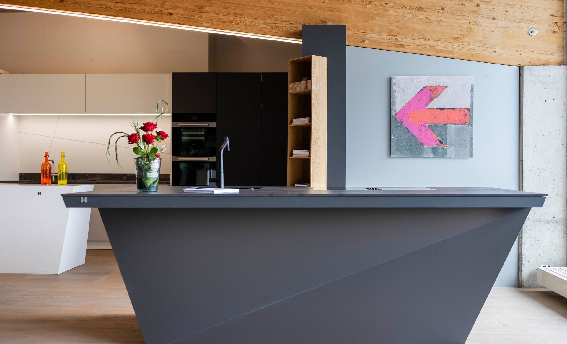 Eine Küche mit einer großen Kochinsel und einem Gemälde an der Wand