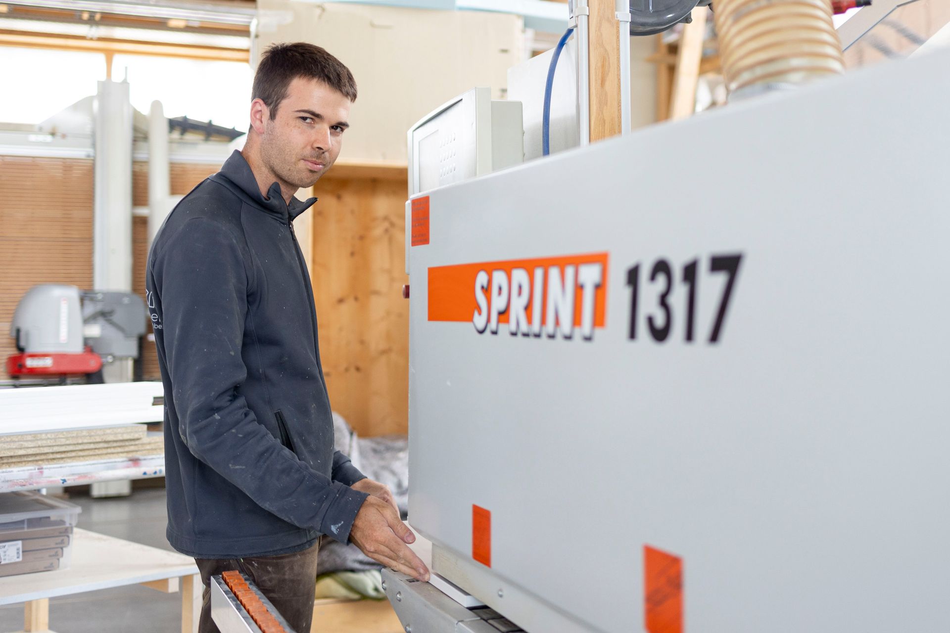 Ein Mann steht vor einer Maschine mit der Aufschrift „Sprint 1317“.