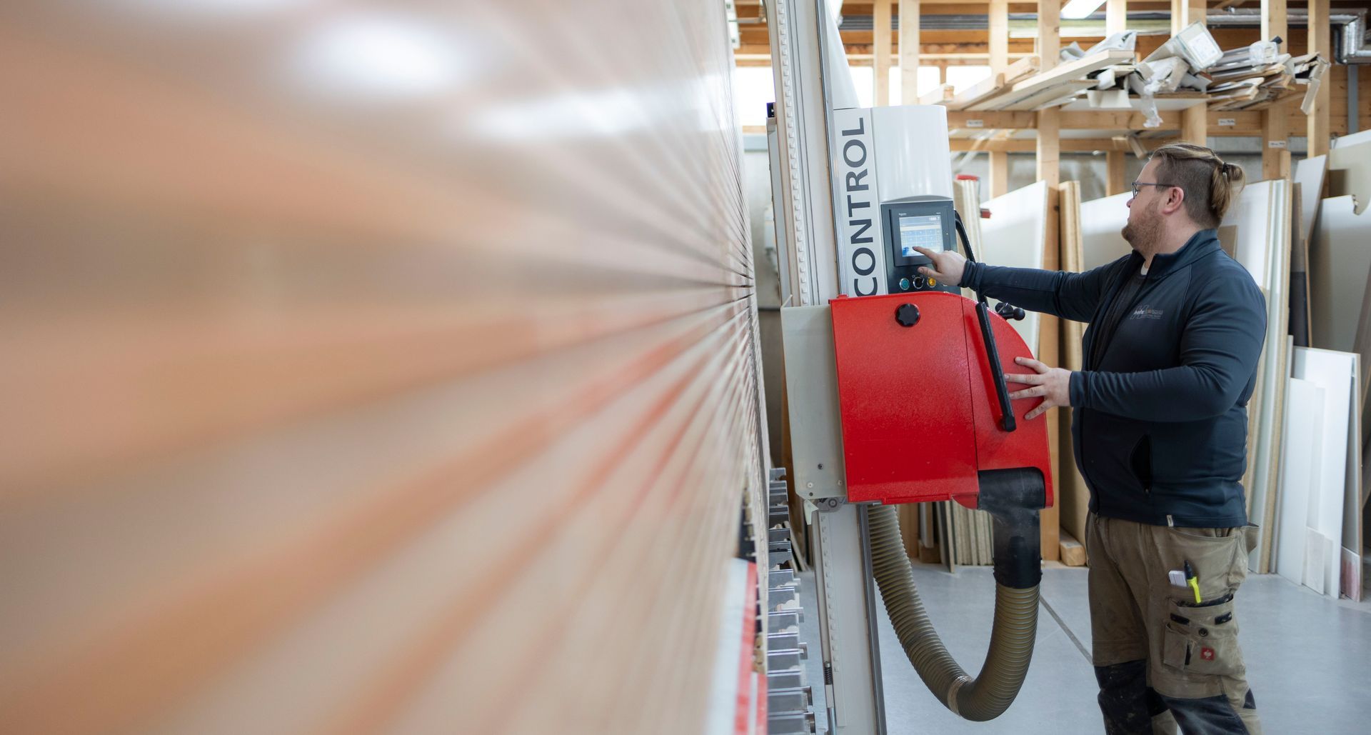 Ein Mann arbeitet in einer Fabrik an einer Maschine.