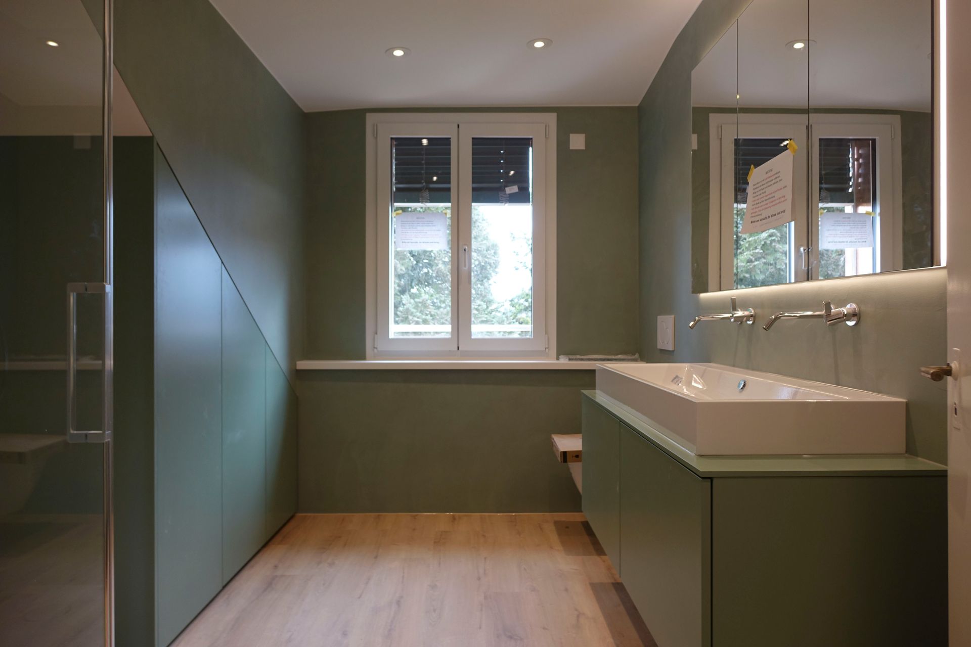 Ein Badezimmer mit Waschbecken, Spiegel und Fenster.