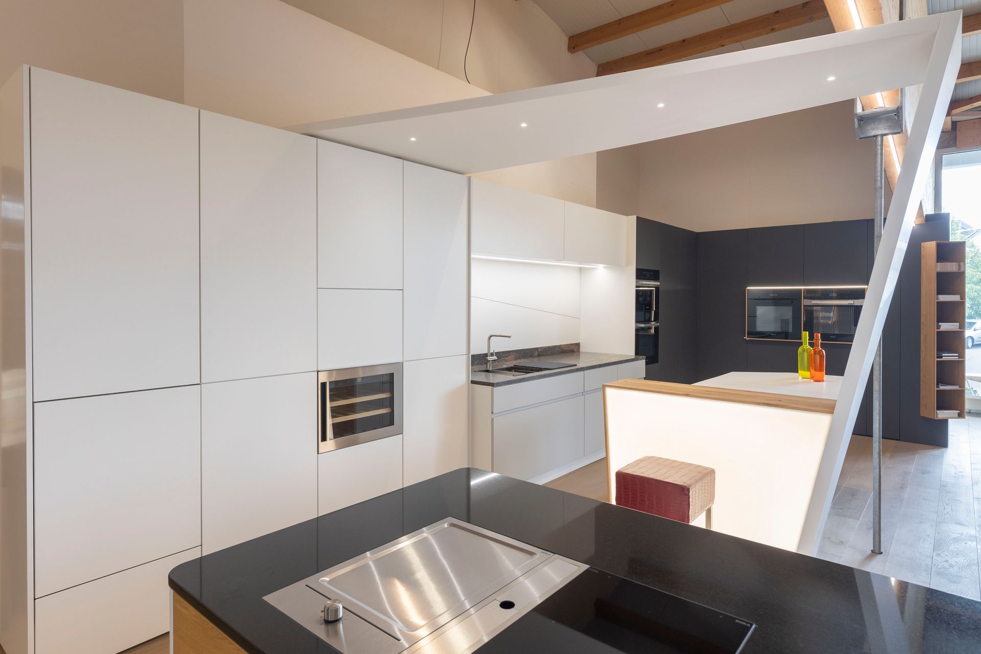 Eine Küche mit weißen Schränken und einer schwarzen Arbeitsplatte