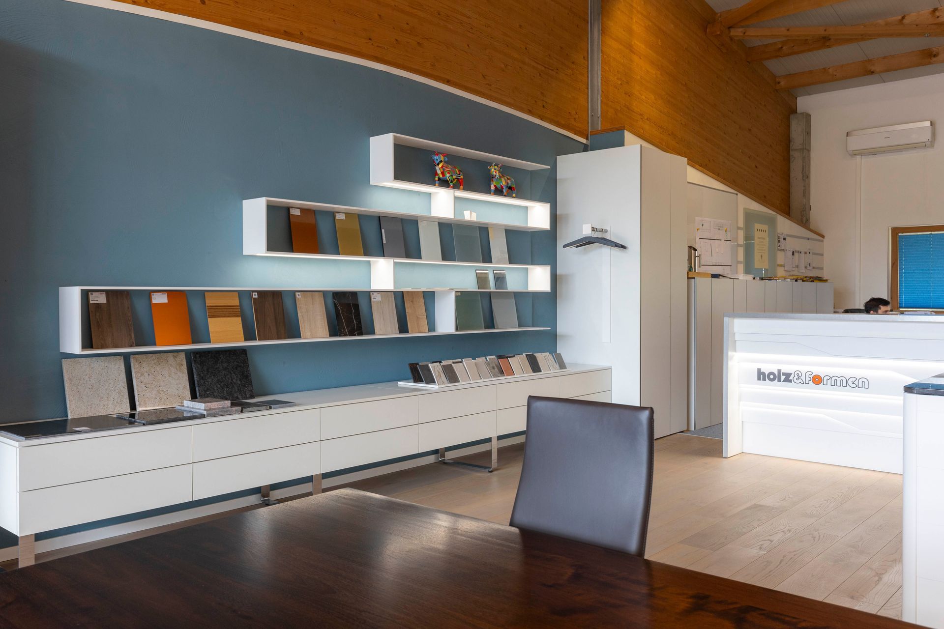 Ein Raum mit einem Tisch und Stühlen und Regalen an der Wand