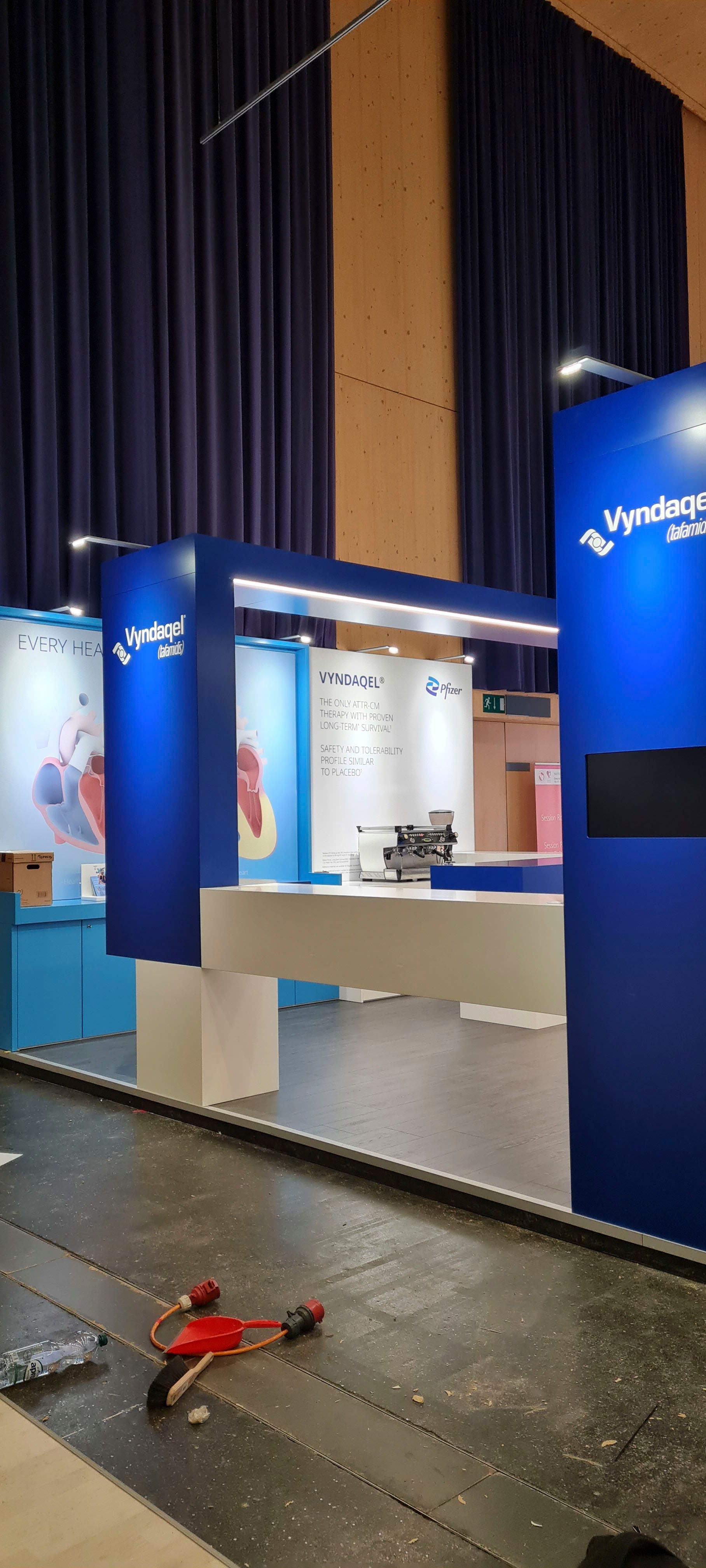 In einem Raum wird ein blau-weißer Stand aufgebaut.