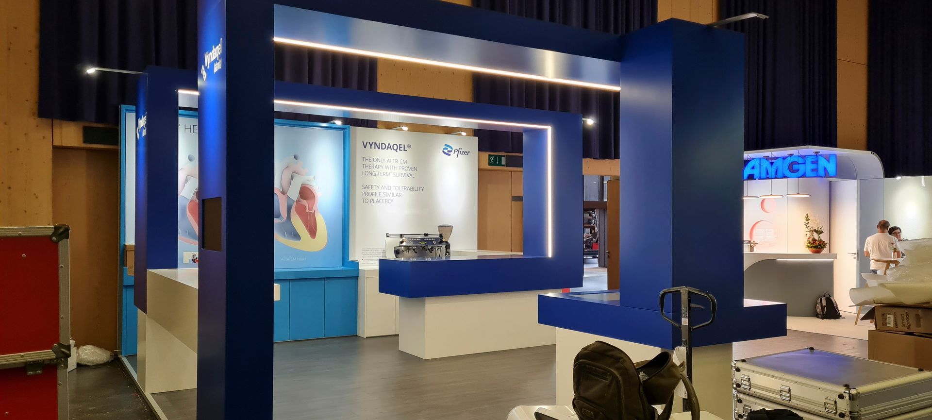 In einem Raum wird ein blau-weißer Stand aufgebaut.