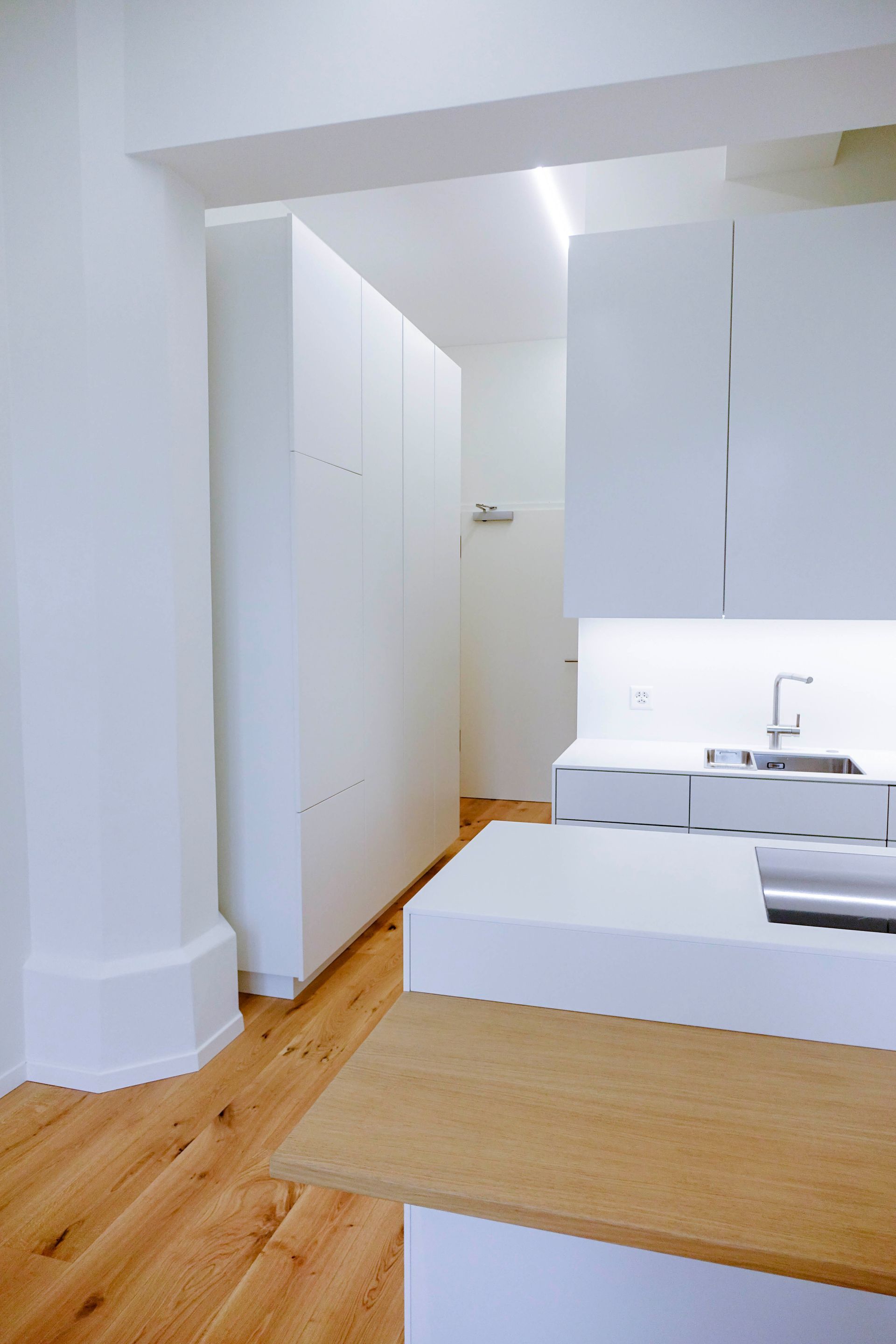 Eine Küche mit weißen Schränken und Holzböden