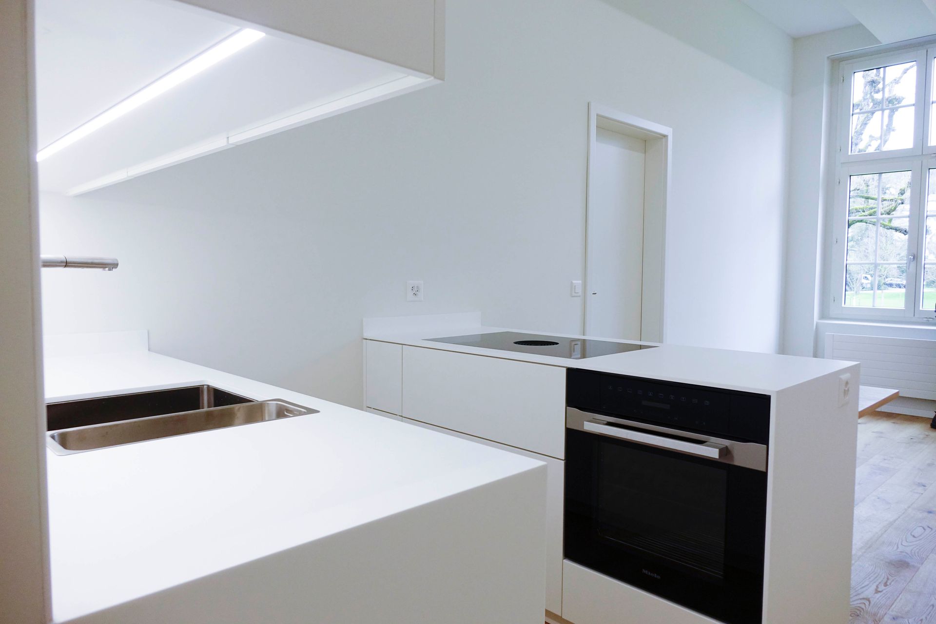 Eine Küche mit weißen Schränken und einem schwarzen Ofen