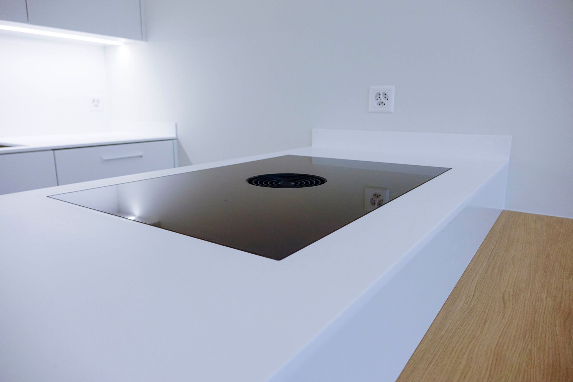 In einer Küche steht auf einer weißen Arbeitsplatte ein Herd mit Backofen.