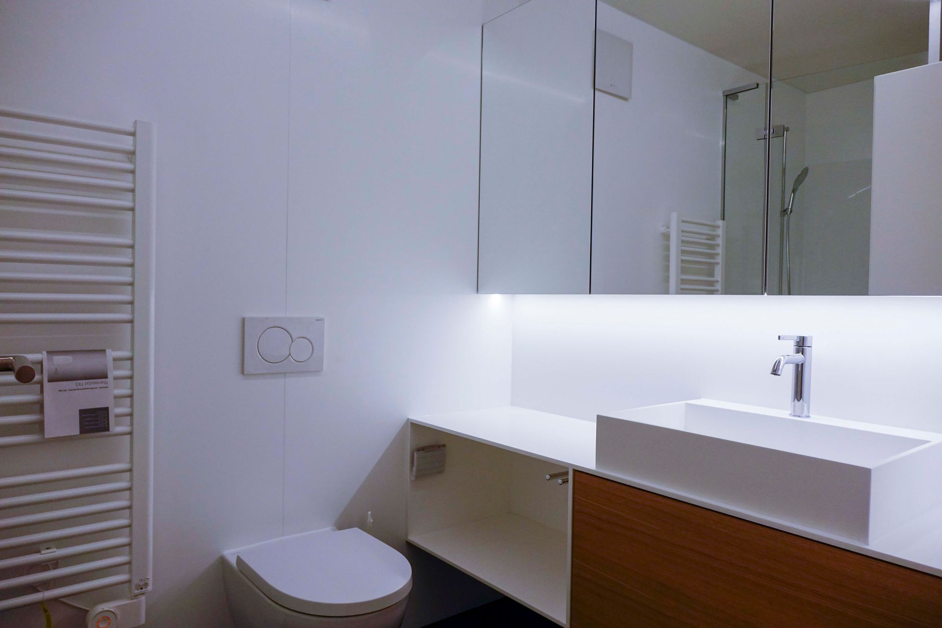 Ein Badezimmer mit Toilette, Waschbecken, Spiegel und Handtuchhalter.