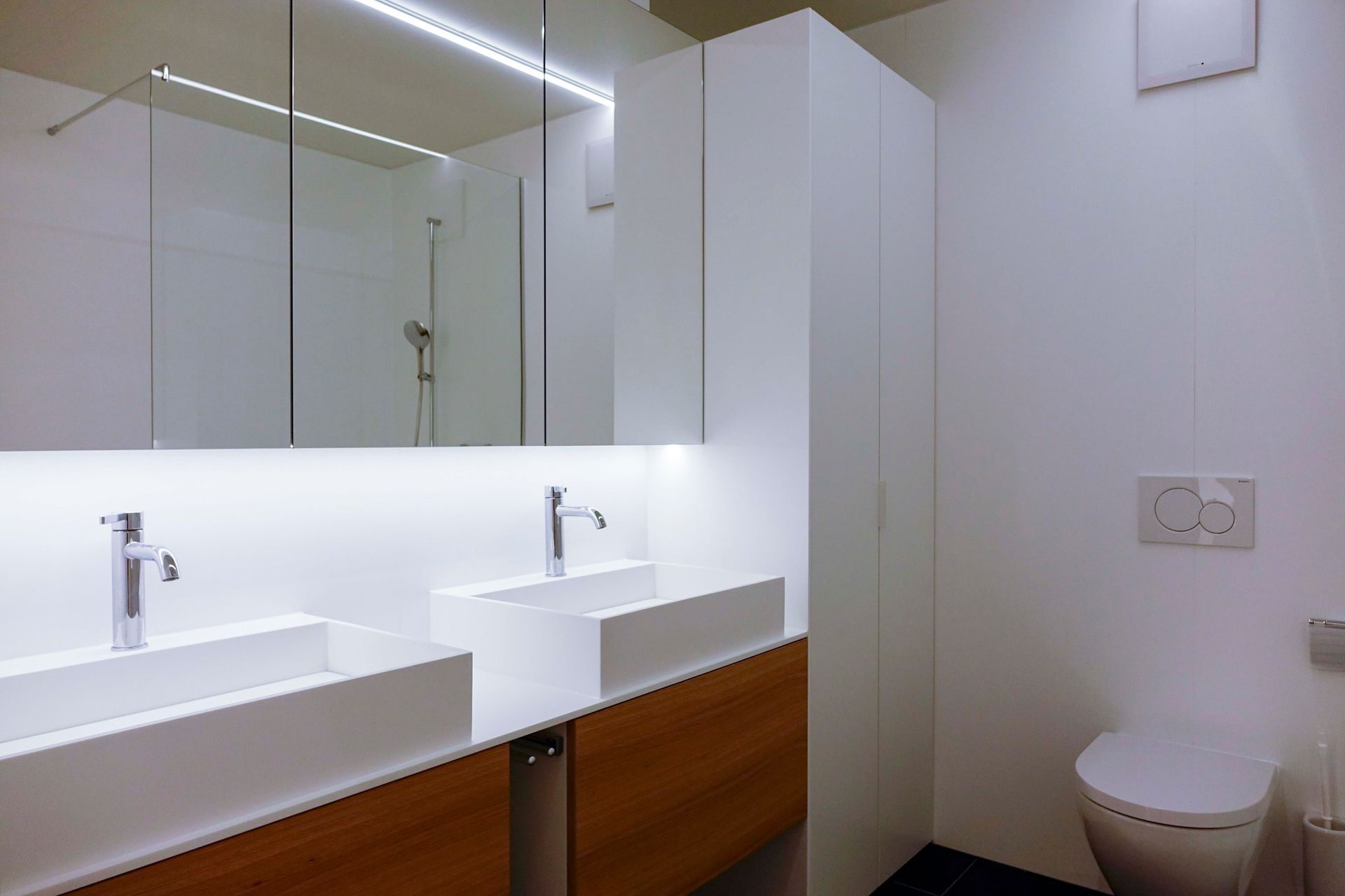 Ein Badezimmer mit zwei Waschbecken und einer Toilette.