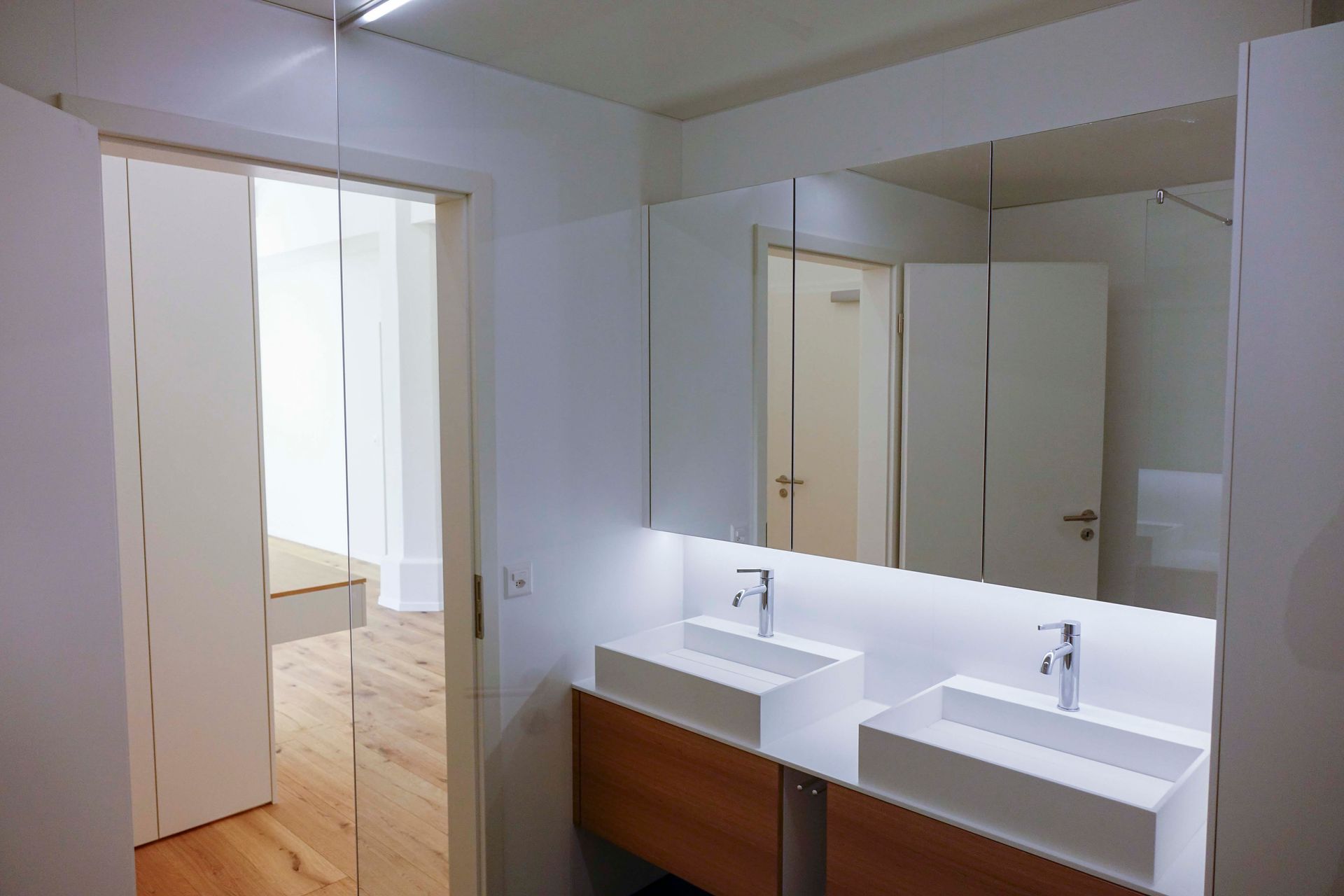 Ein Badezimmer mit zwei Waschbecken und einem großen Spiegel.