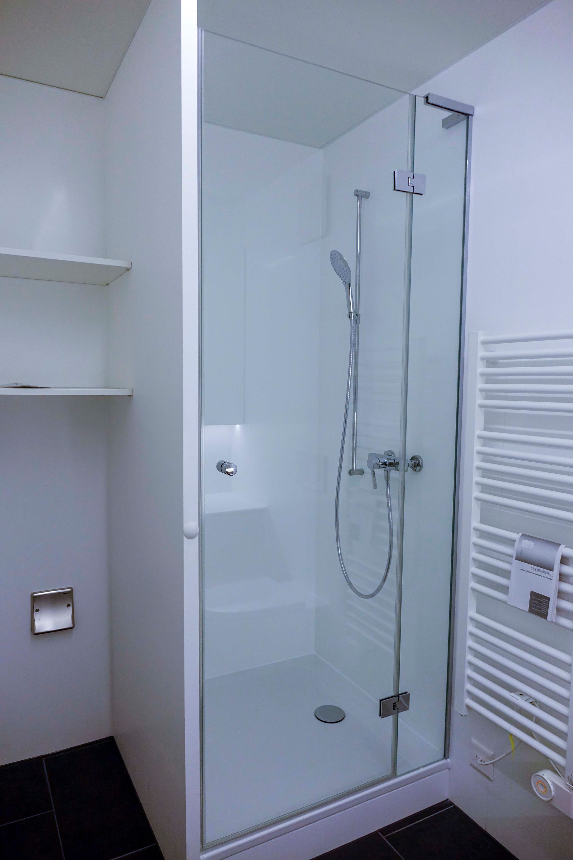 Ein Badezimmer mit Dusche und Handtuchhalter.