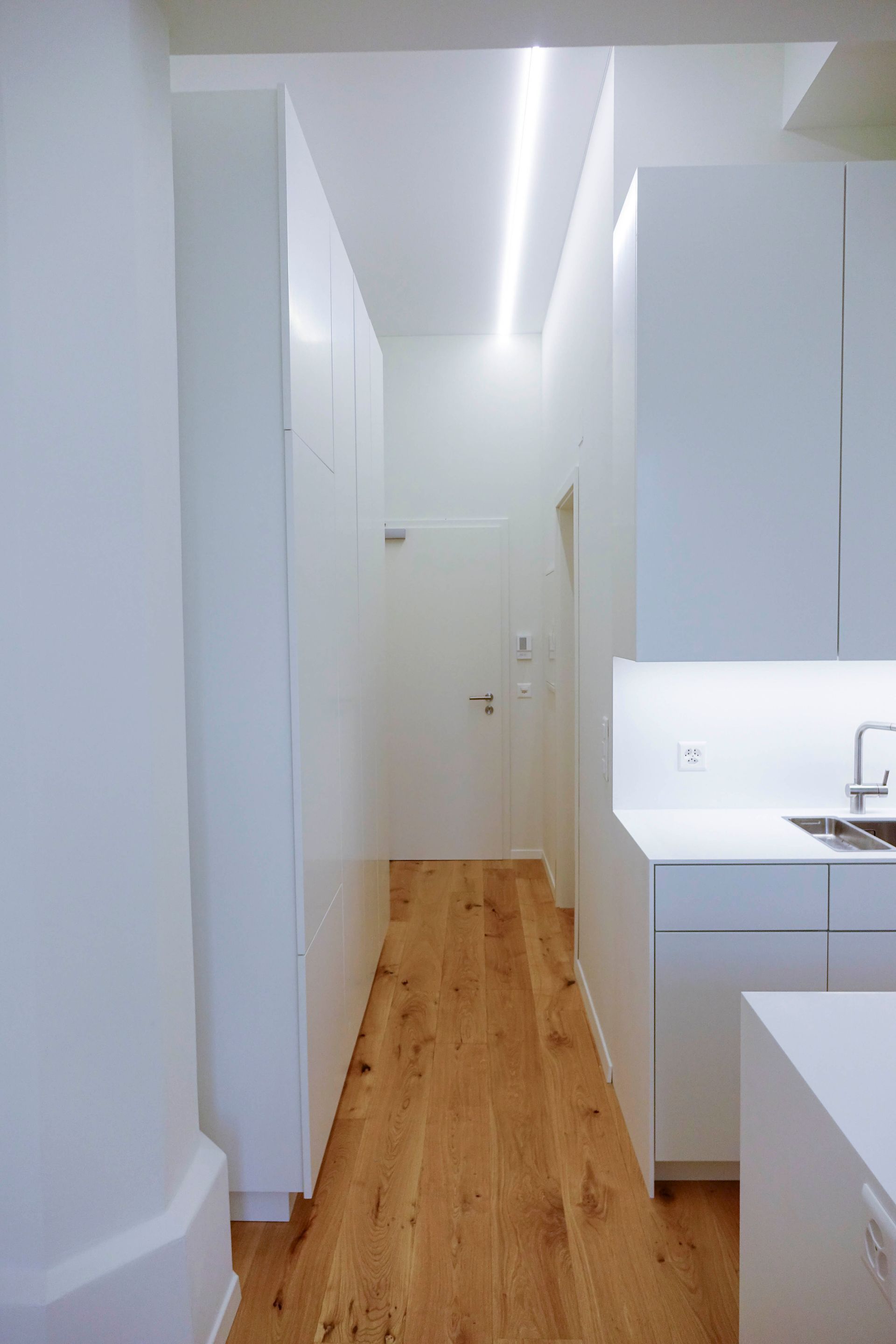 Eine Küche mit weißen Schränken und Holzböden