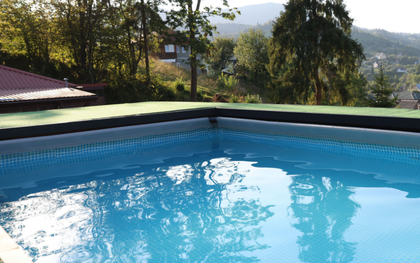 Une piscine avec des escaliers et des plantes en pot en arrière-plan.