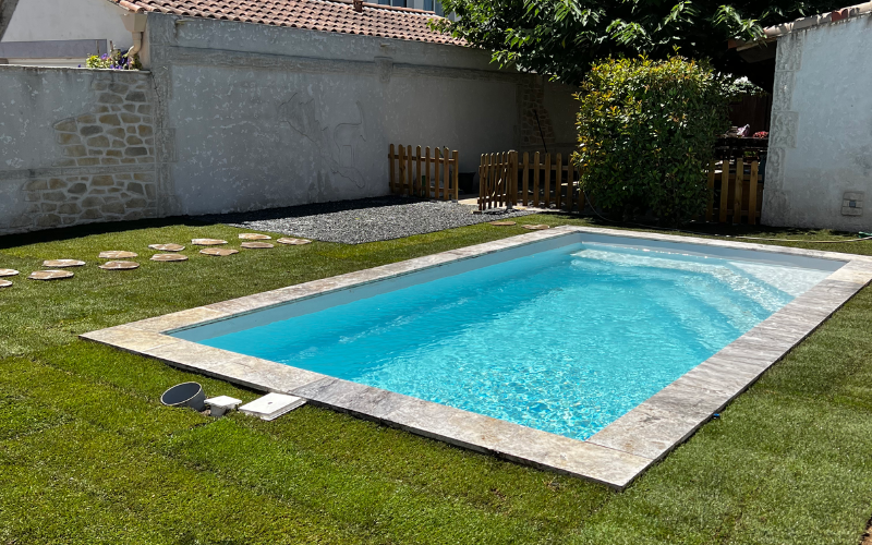 Une piscine avec des escaliers et des plantes en pot en arrière-plan.