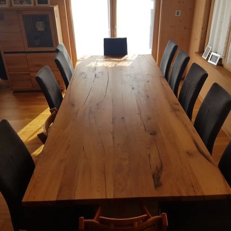 Ein langer Esstisch aus Holz mit natürlicher Kante