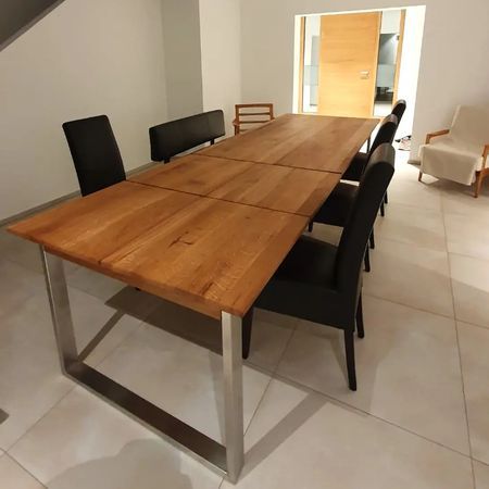 Ein langer Esstisch aus Holz mit U-förmigem Metallgestell