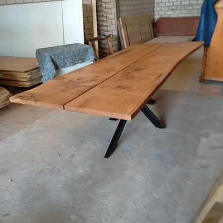 Ein großer Esstisch aus hellem Holz mit natürlicher Baumkante