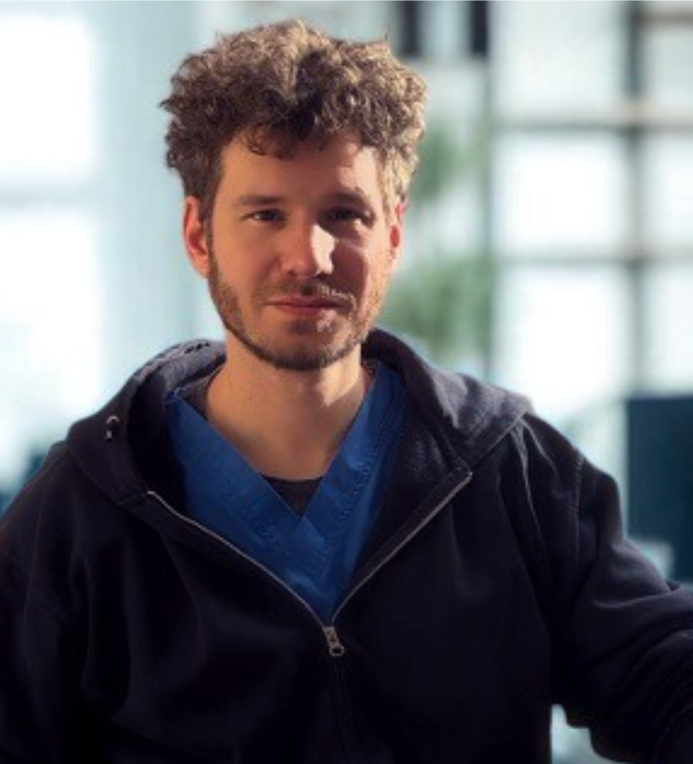 Eine Frau mit Brille und blauem Hemd lächelt