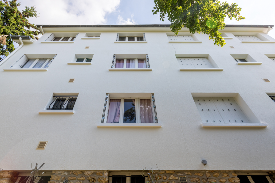 Vue en contre-plongée de la façade blanche d'un immeuble.