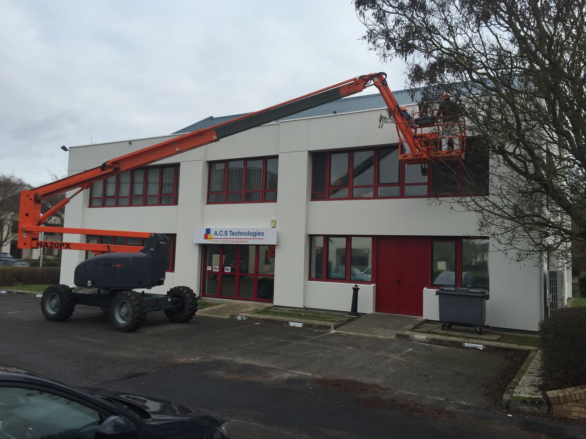 Deux peintres sur une plateforme en hauteur.