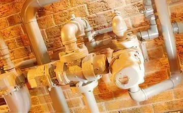 Un montón de tubos cuelgan de una pared de ladrillos.