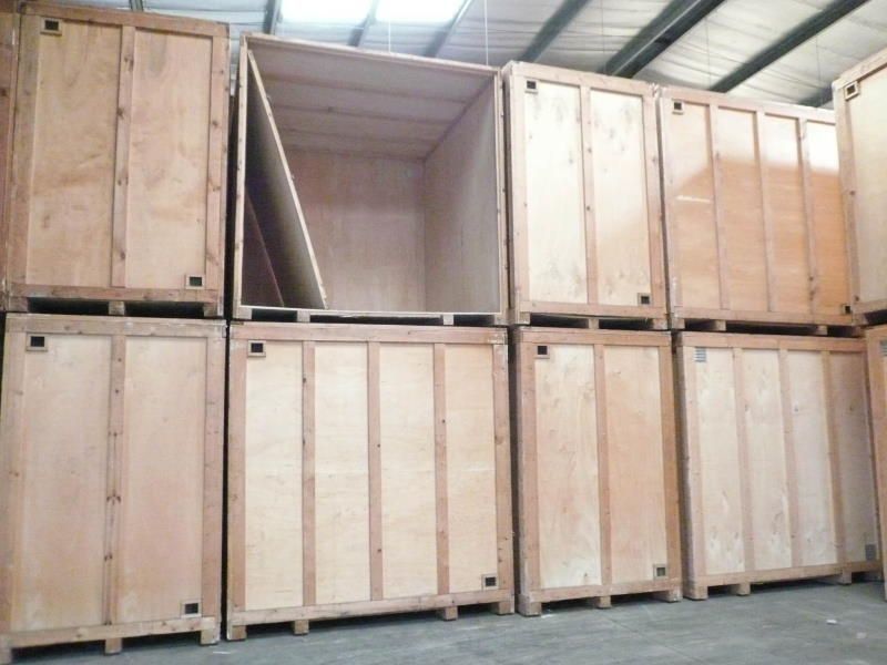Cajas de madera apiladas en un almacén. Una de ellas está abierta, revelando un interior vacío.