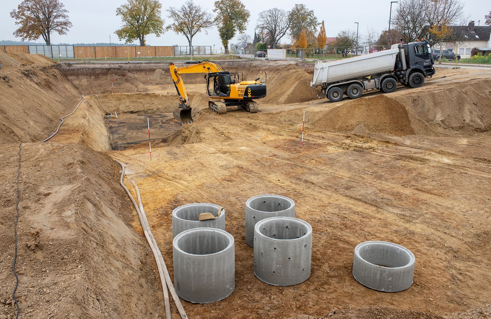 Eine Baustelle mit Betonringen und einem Muldenkipper.