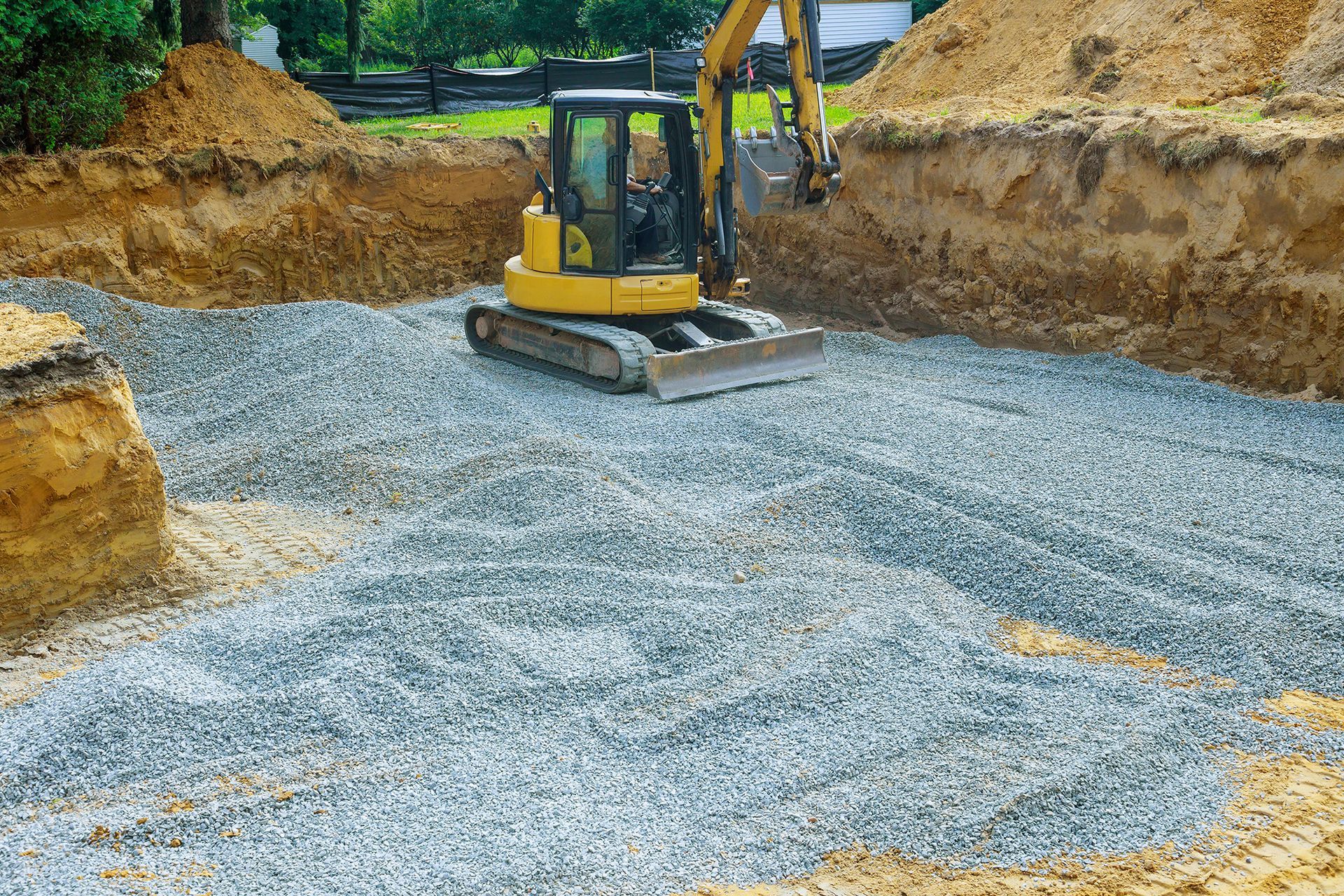 Ein gelber Bagger gräbt ein Loch in den Boden.