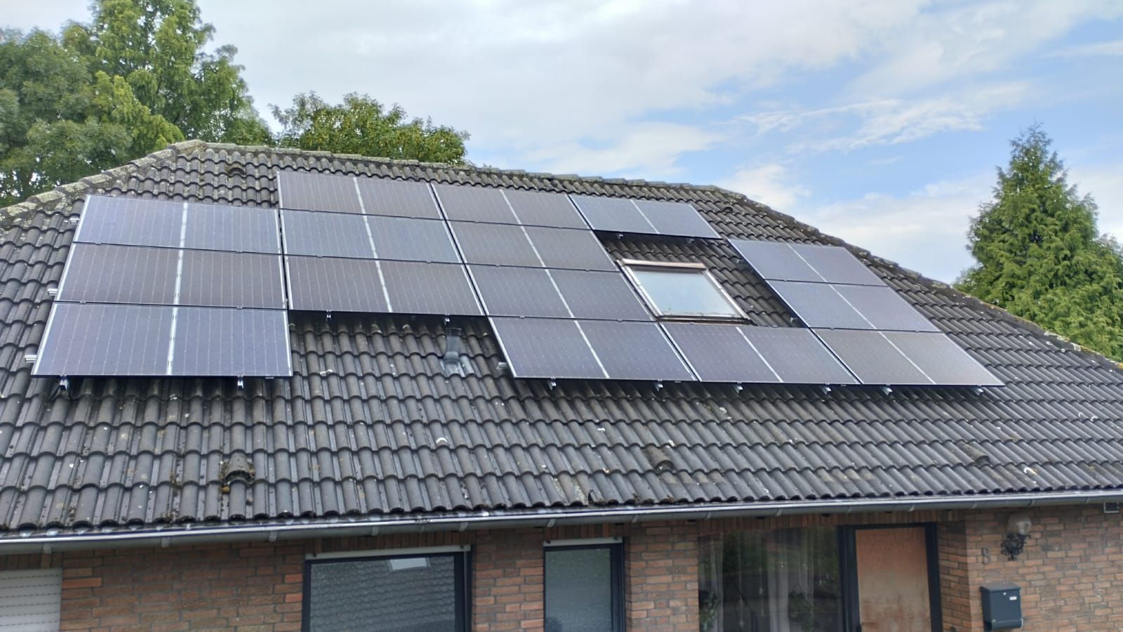 Ein Haus mit vielen Sonnenkollektoren auf dem Dach