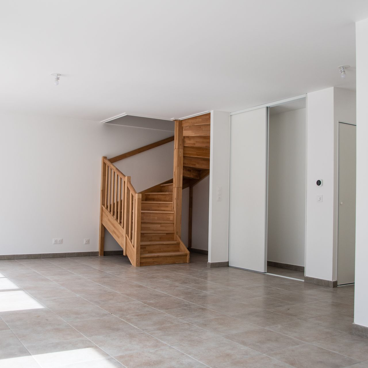 Une pièce avec un escalier dans l'angle