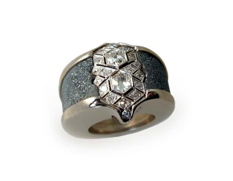Diamant- und Silberring mit strukturiertem, dunkelgrauem Band.