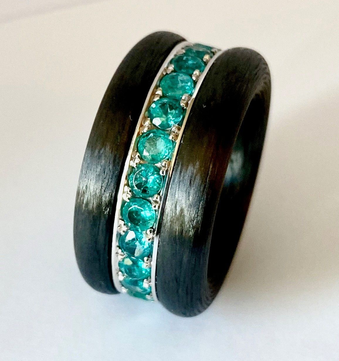 Schwarzer Ring mit einem zentralen Band aus Türkis-Edelsteinen