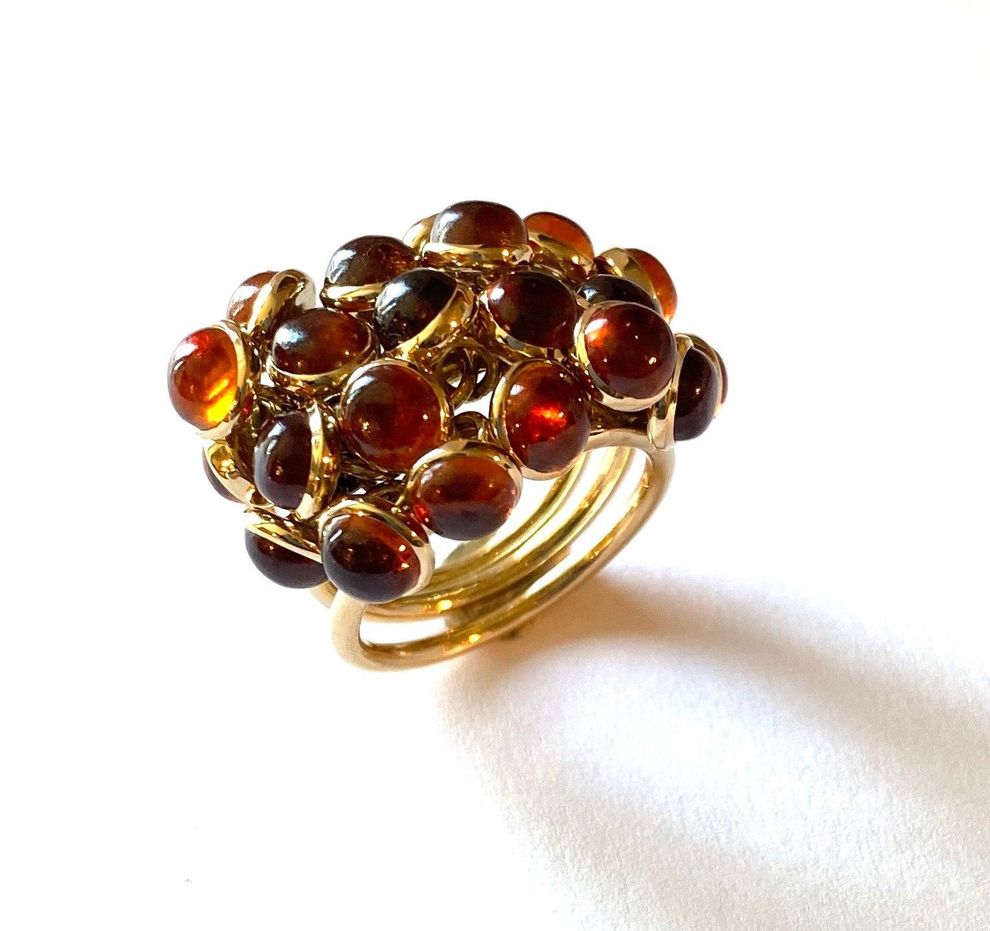 Goldring mit einer Gruppe bernsteinfarbener, runder Steine.
