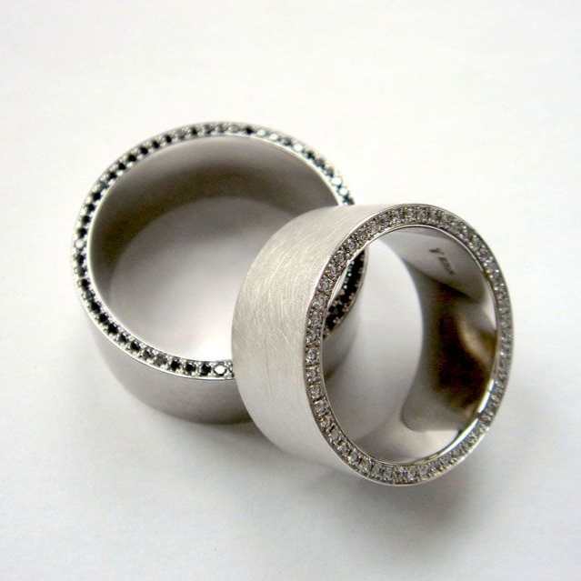 Zwei silberne Ringe mit Pavé-Steinen auf weißem Hintergrund