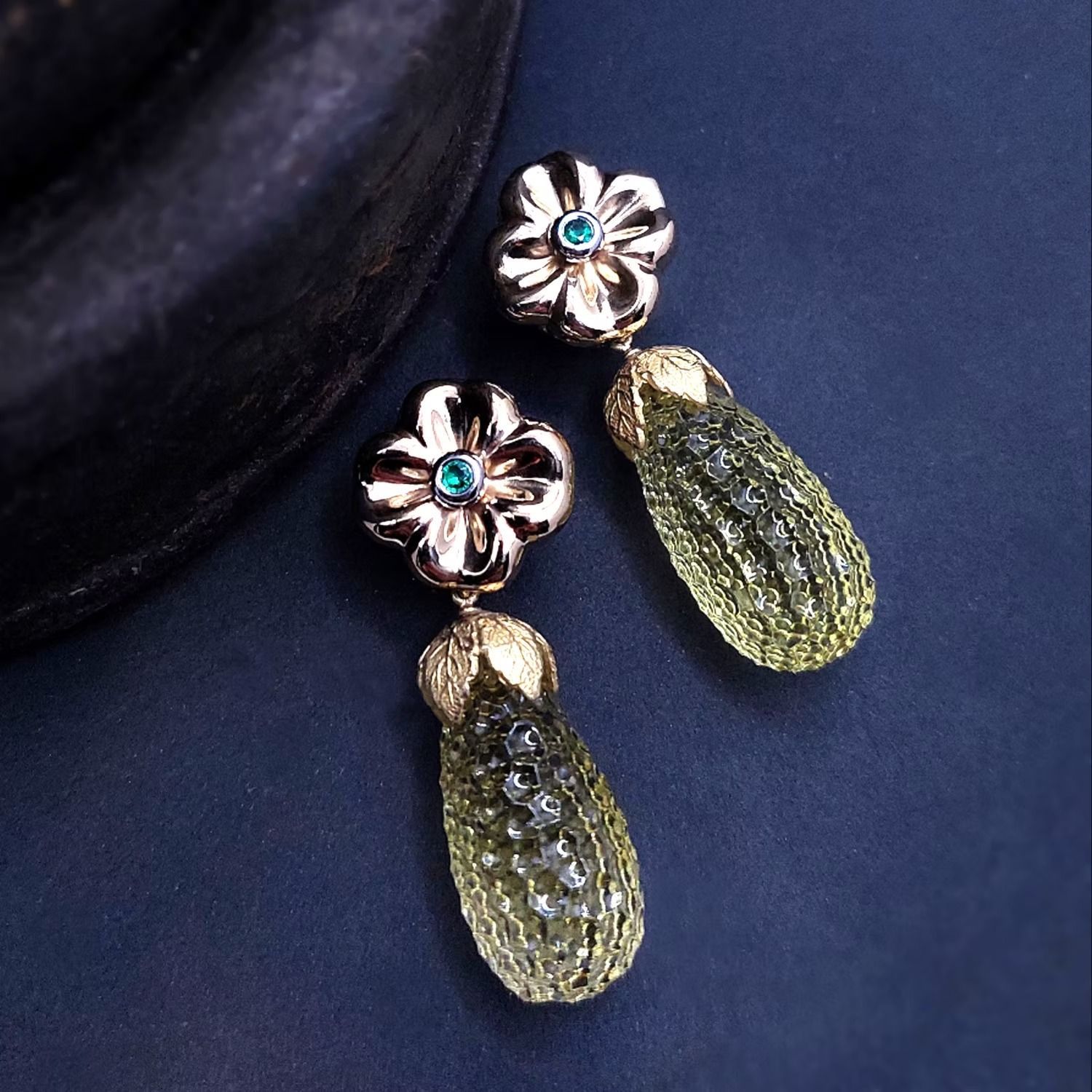 Goldene Ohrringe mit großen gelbbraunen Edelsteinen und tropfenförmigen Anhängern.