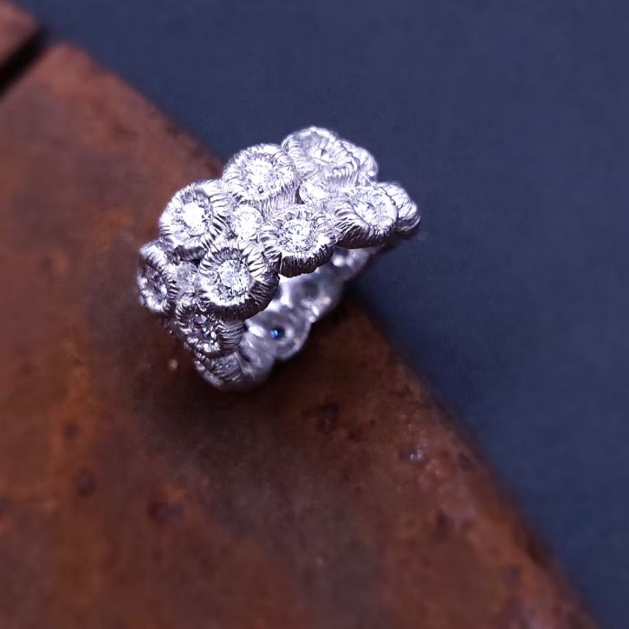 Diamantring mit Cluster-Design auf rustikaler Oberfläche.