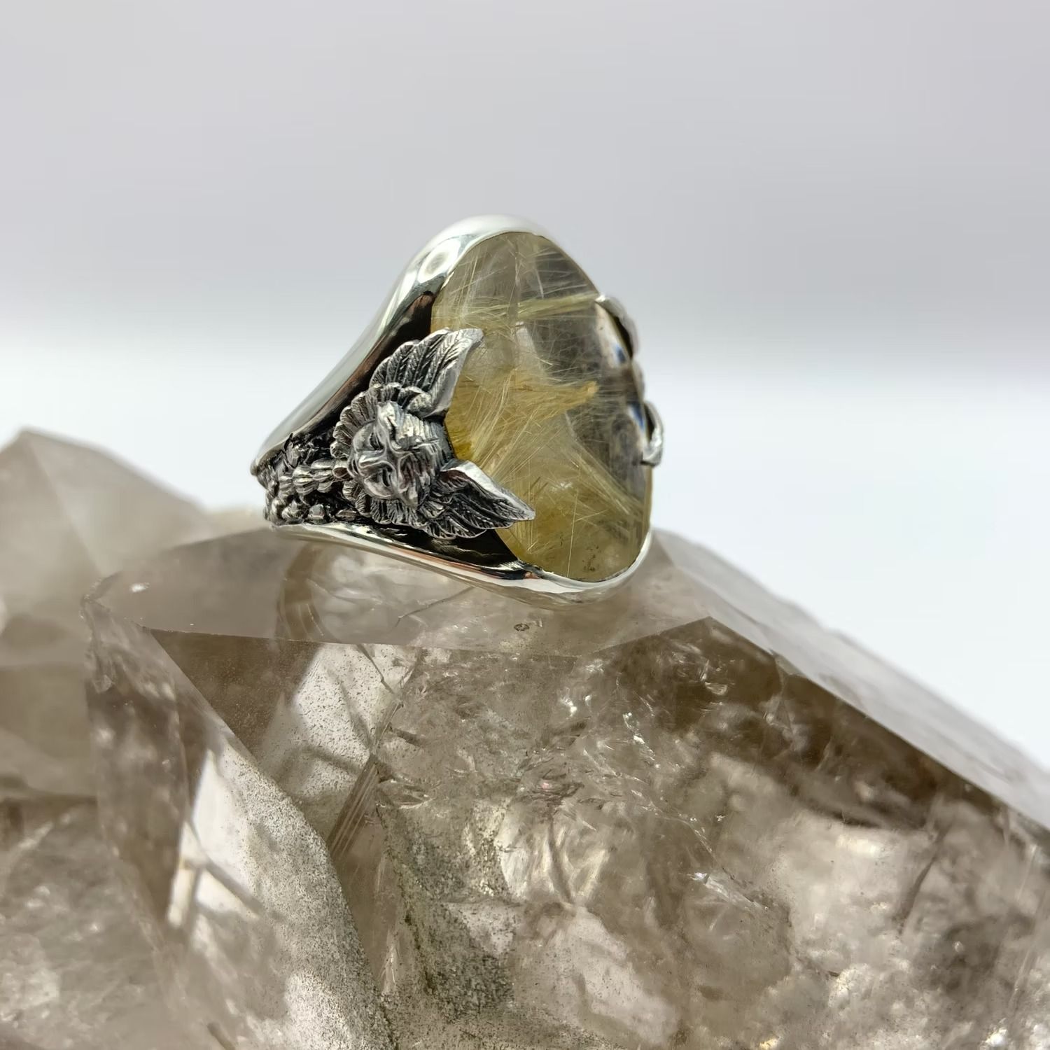 Silberring mit einem gelbgoldenen Kristallstein, der auf einem klaren Quarzkristall gefasst ist.