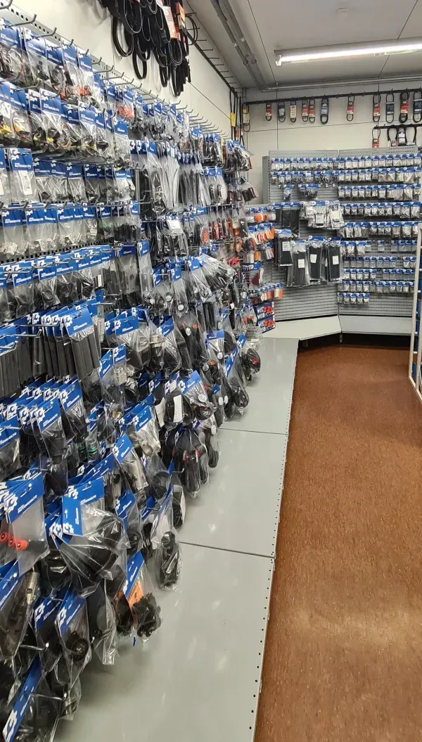 Kaupan käytävä, jonka reunustamina roikkuvat riveittäin sinisiin pakattuihin tuotteisiin pakatut tavarat.