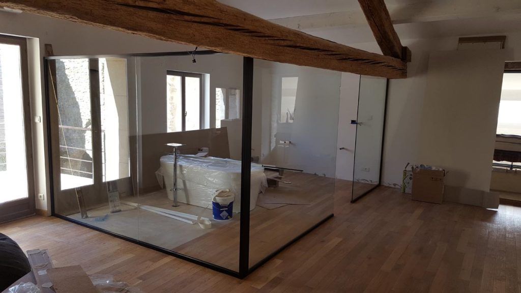 Une salle de bains avec cloison en verre