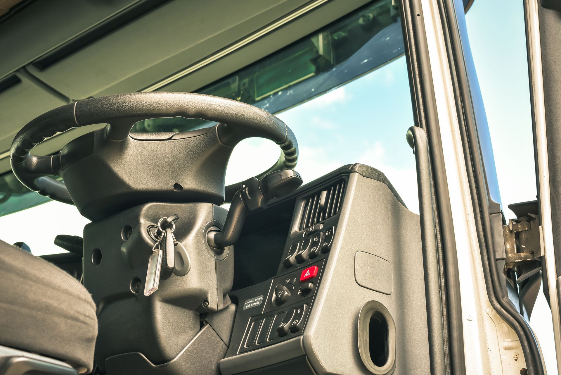 Intérieur de la cabine d'un camion avec volant et tableau de bord en plein soleil