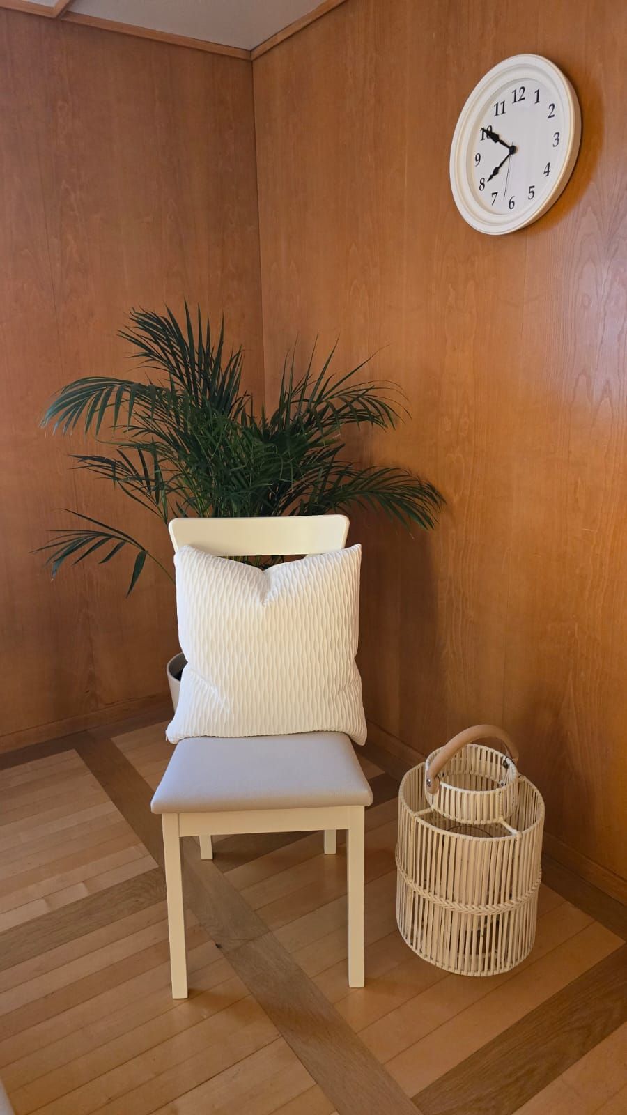 An der Wand über dem Stuhl hängt eine Uhr.