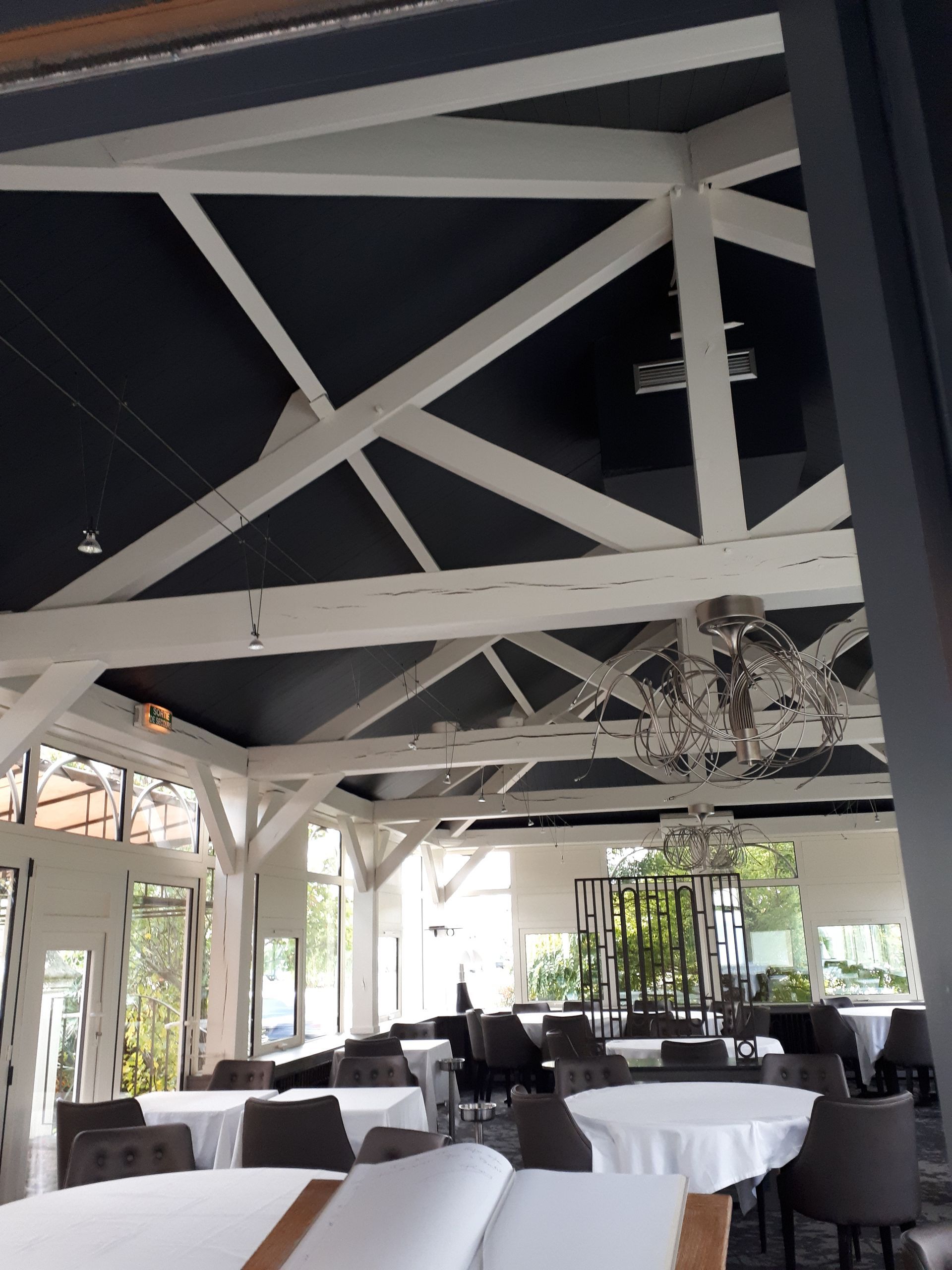 Charpente en bois blanche avec lustre en fer