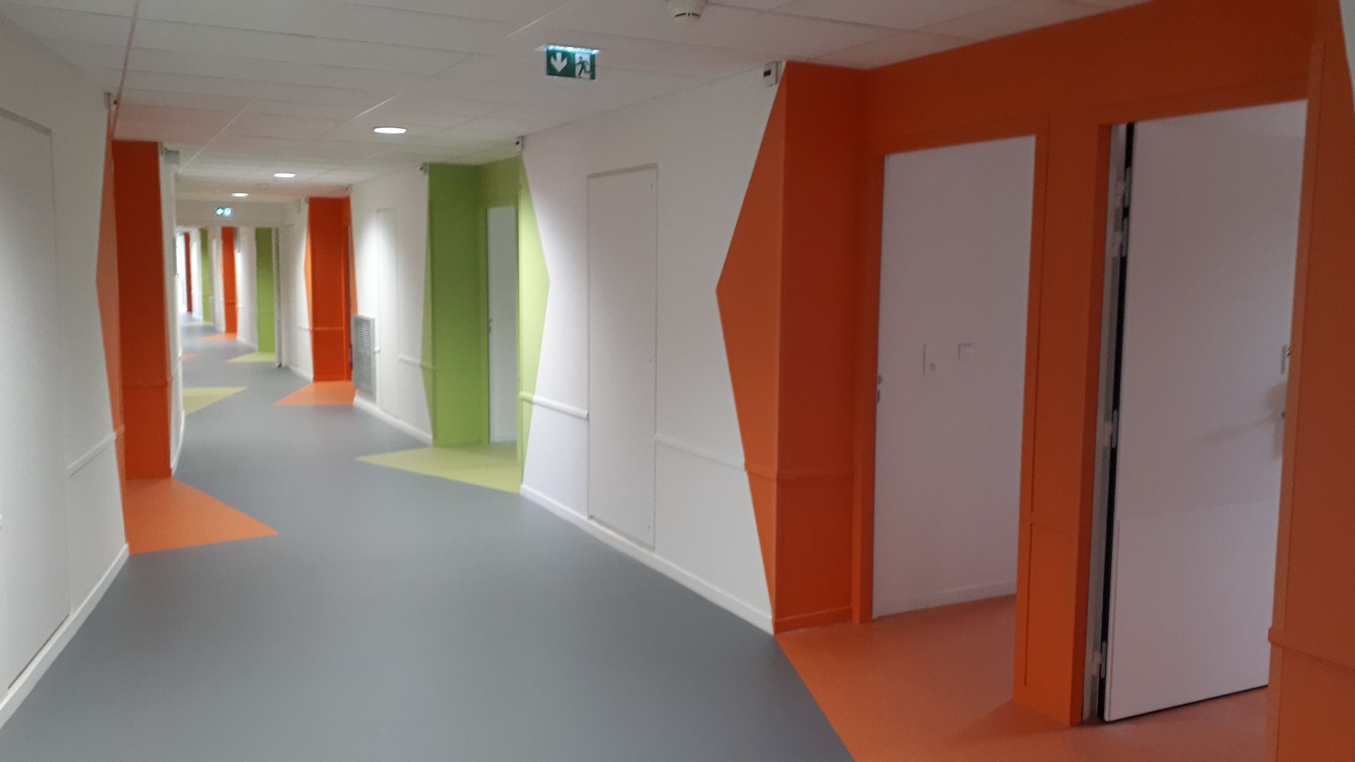 Mur et sol en PVC blanc, orange et vert d'un internat