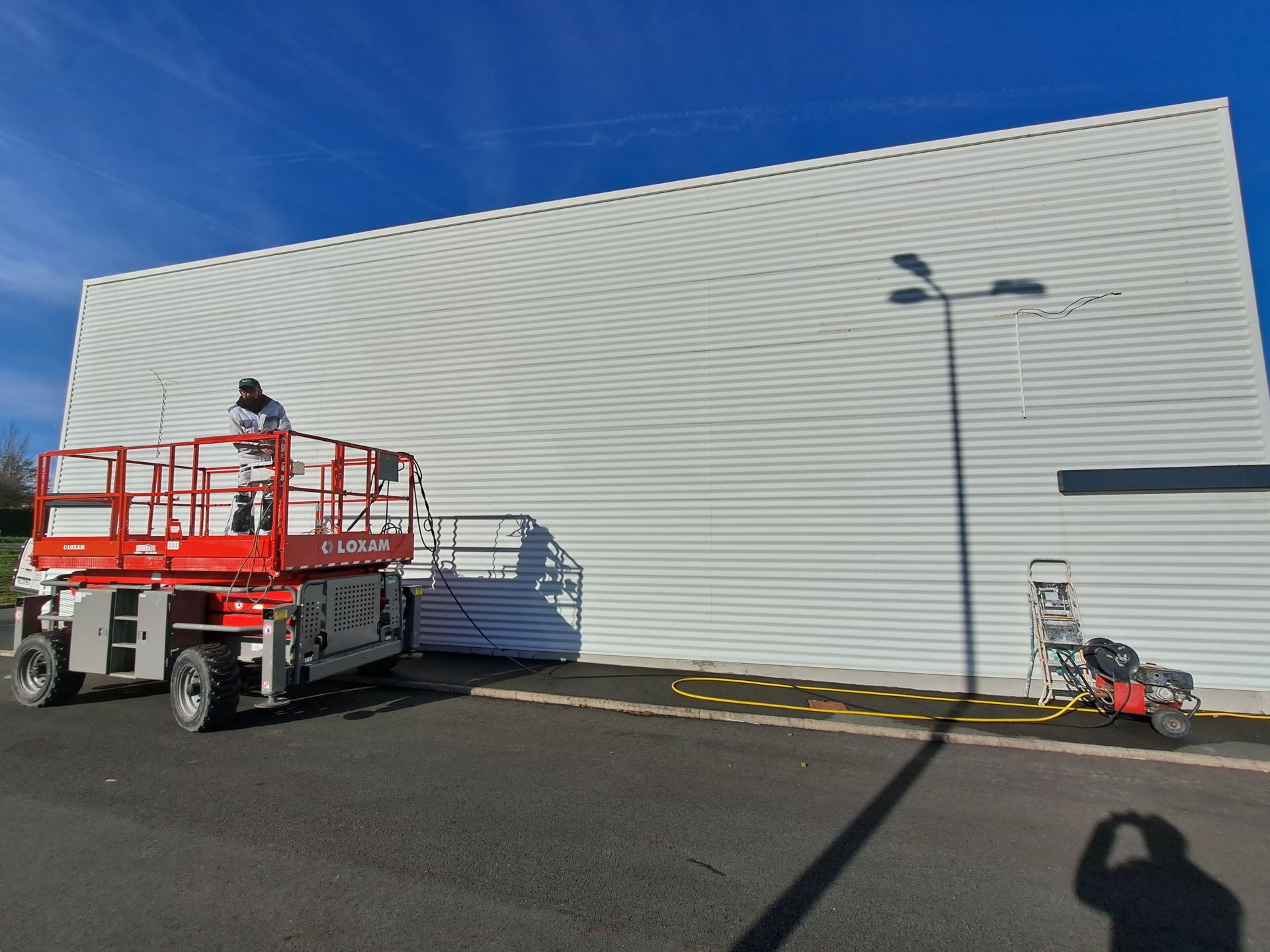 Ouvrier en train de nettoyer bardage extérieur