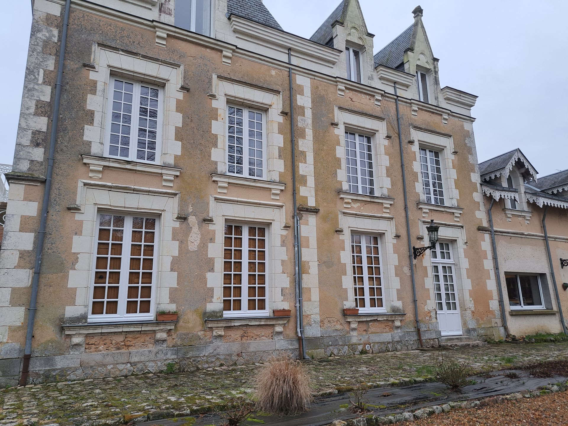 Photo extérieure d'une maison à trois étages et grandes fenêtres