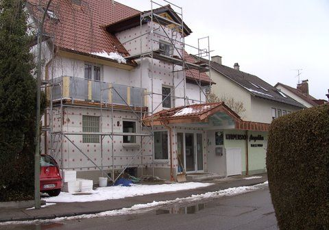 Das hölzerne Fachwerk und die Dachsparren eines im Bau befindlichen Hausdaches vor strahlend blauem Himmel.