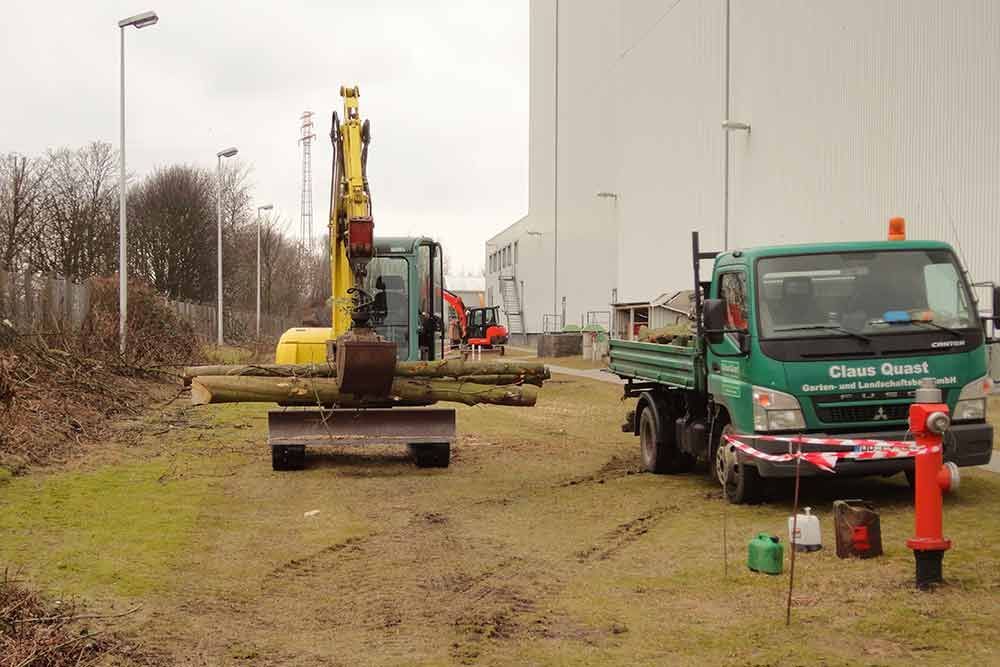 Ein grüner LKW parkt neben einem gelben Bagger